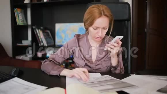 有魅力的女商人在办公室里拿着电脑和文件打着电话视频的预览图