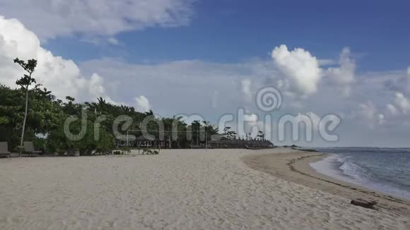 沙滩全景热带度假胜地有躺椅和遮阳篷巴厘岛印度尼西亚视频的预览图
