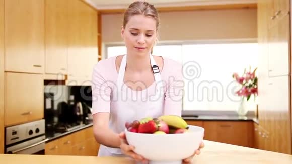年轻女子把一碗水果放在工作台上视频的预览图