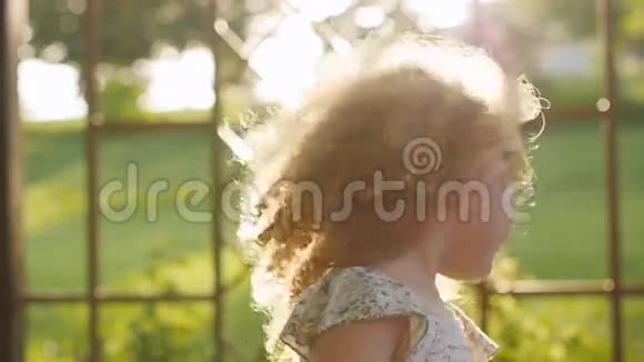 快乐的卷发女孩在夕阳下笑视频的预览图