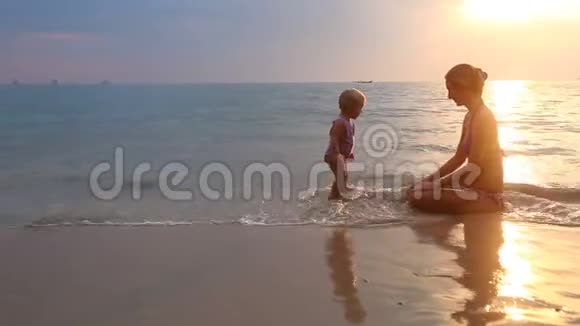 日落时与妈妈在沙滩上玩耍视频的预览图
