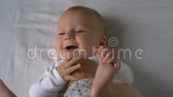妈妈挠了挠孩子的痒他躺在床上笑视频的预览图