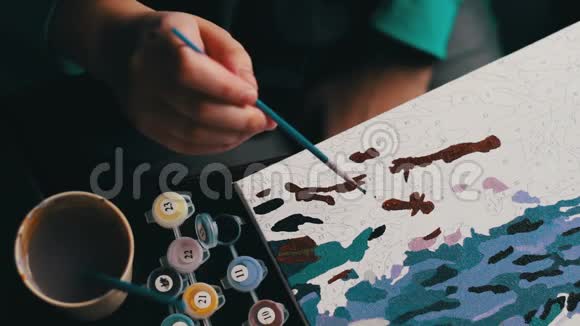 女孩在画布上用蓝色丙烯酸颜料画了一幅美丽的画成年人的着色抗逆视频的预览图