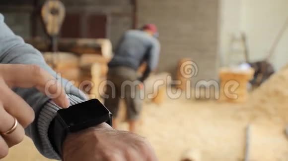 青年林业工程师在木头前触摸智能手表视频的预览图