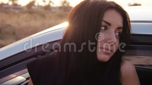 日落时分小女孩在汽车附近凝视和亲吻视频的预览图