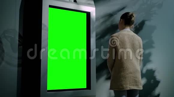 在展览厅看到空白绿色展示亭的女人绿色屏幕概念视频的预览图
