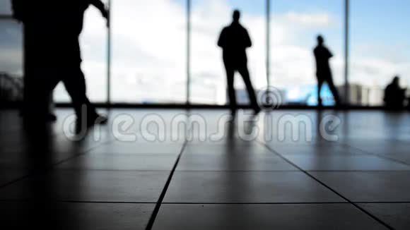 机场窗前等候登机的旅客剪影视频的预览图