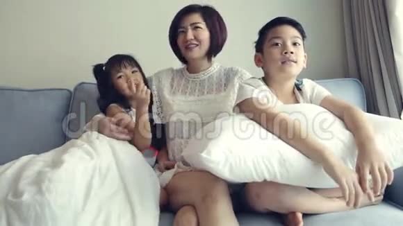 年轻的亚洲家庭玩和看电视视频的预览图