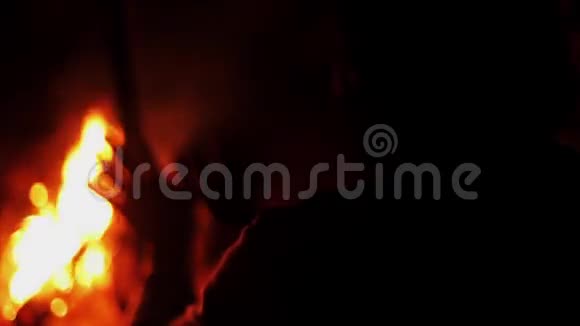人在燃烧篝火时加热双手集中注意力夏夜野营视频的预览图