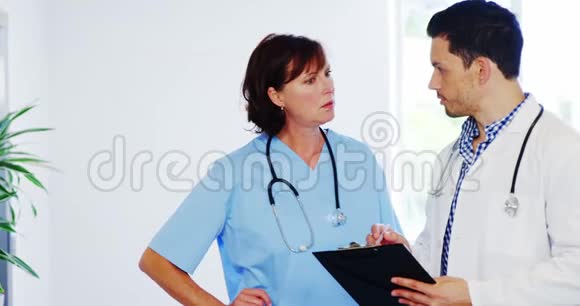 护士和医生在走廊上讨论剪贴板视频的预览图