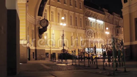 晚上可以看到有照明的建筑物手表栅栏和人的街道视频的预览图