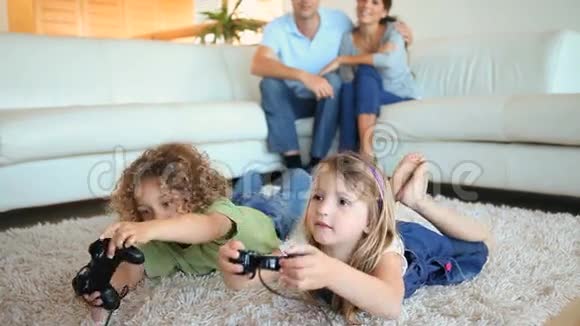孩子们在地毯上玩电子游戏视频的预览图