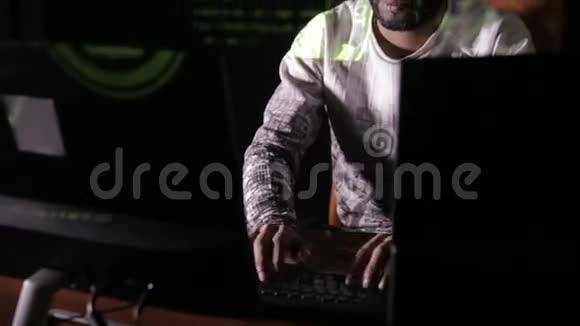 男性阿拉伯黑客在黑暗中黑客入侵电脑他脸上的电脑密码视频的预览图