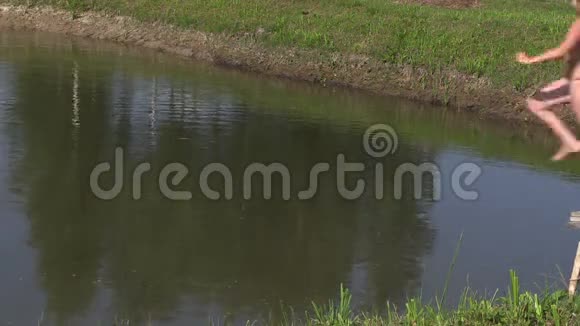 放大女孩在农村池塘里跳跃夏天池塘里的浪花视频的预览图