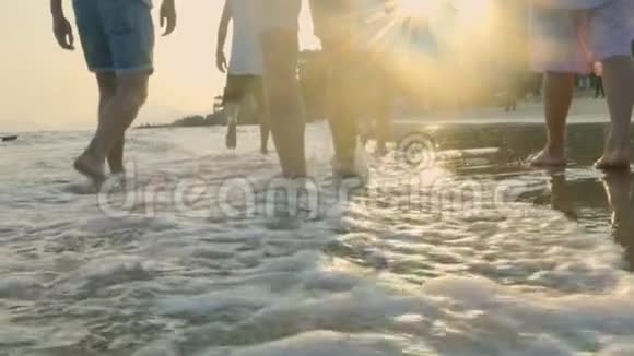 亚洲年轻人在海水中的海滩上散步视频的预览图