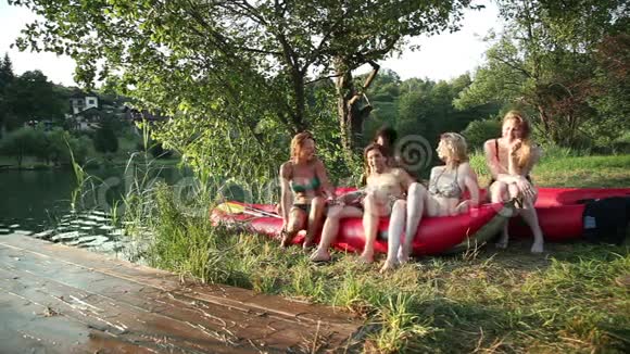 一群朋友在日落时骑着独木舟在河边休息视频的预览图