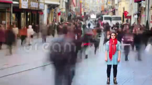 年轻女子摆姿势忙碌的街道人们四处走动4K视频的预览图