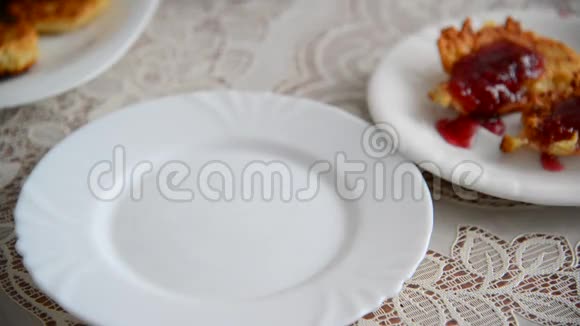 家庭主妇把奶酪薄饼放在盘子里倒入覆盆子果酱视频的预览图
