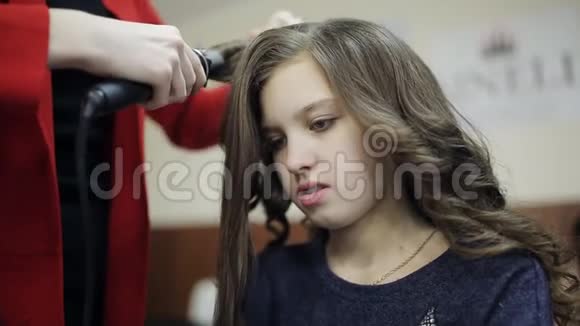 理发师为一个可爱的女孩创造一个发型的最后阶段专业理发师发型师视频的预览图