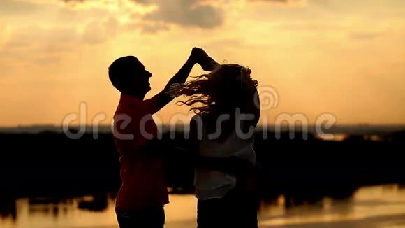 日落时的爱情剪影跳舞和亲吻视频的预览图