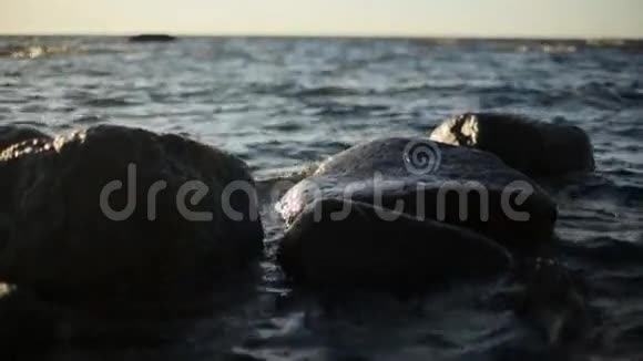 在阳光的照射下海浪在海岸的岩石上撞击没有人慢动作视频的预览图