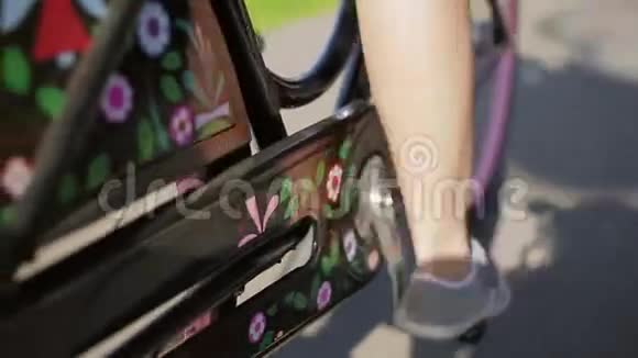 骑自行车的女孩在夏天把两条腿都扔在车架上脚和踏板集中在视频的预览图