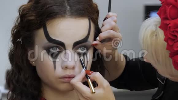 万圣节化妆很简单美容院的女孩在模型的表面应用文体模式A的工作视频的预览图