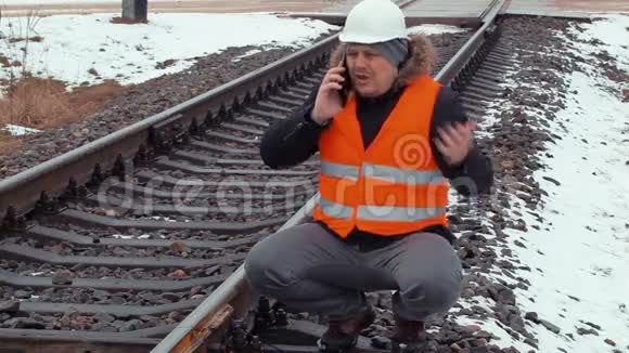 愤怒的铁路工人在铁路附近打电话视频的预览图