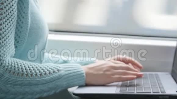 年轻女孩坐火车用笔记本在铁路上女性手按键盘打字视频的预览图