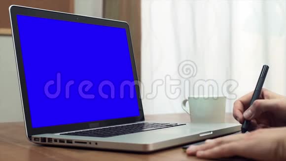 一位年轻设计师用平板电脑和一台笔记本电脑紧紧抓住他的手视频的预览图