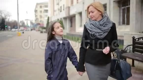 母女俩在街上散步寒冷的秋天视频的预览图