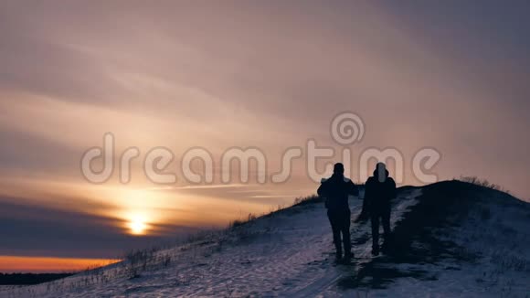 人们冬天剪影雪光一群游客走在夕阳的剪影山上慢视频视频的预览图