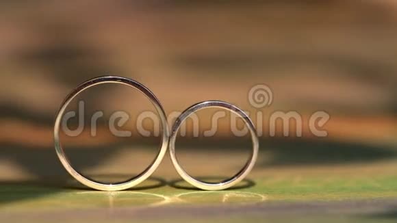 结婚戒指躺在木制的表面上视频的预览图