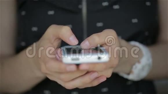 合上年轻女子黑色连衣裙手指在智能手机上打字视频的预览图