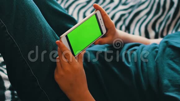 在家里的沙发上用智能手机发色键上网的青少年视频的预览图