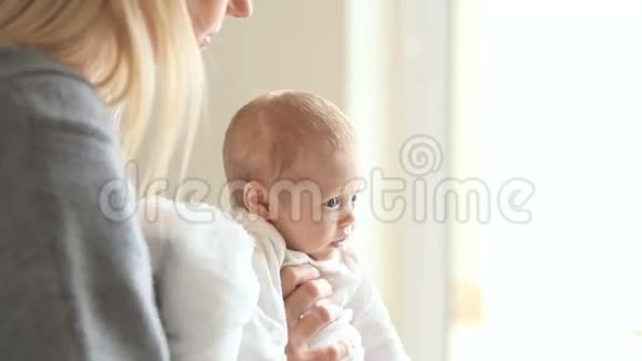 女人拿起一个婴儿亲吻他的脸颊视频的预览图
