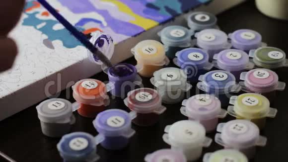 根据数字用Lilac丙烯酸颜料作画许多彩色颜料在罐子里作画视频的预览图