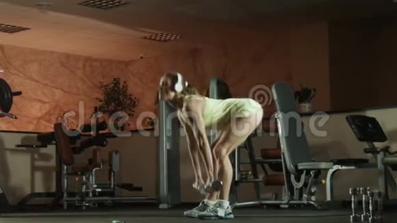 女人在健身皮拉茨健身房用哑铃做运动视频的预览图