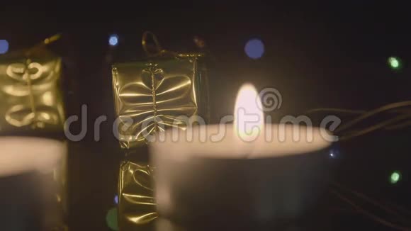 茶点蜡烛和黄金礼物作为圣诞装饰在闪烁的花环后面视频的预览图