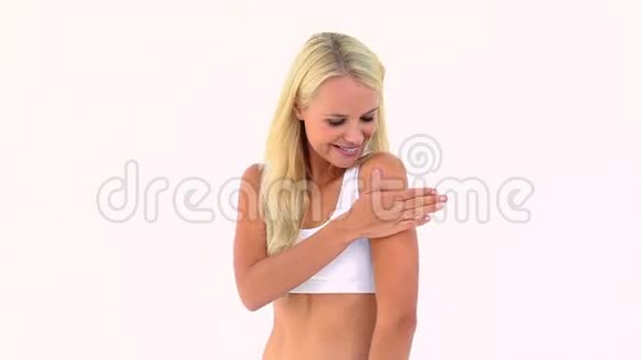 金发美女在她的手臂上涂抹保湿霜视频的预览图