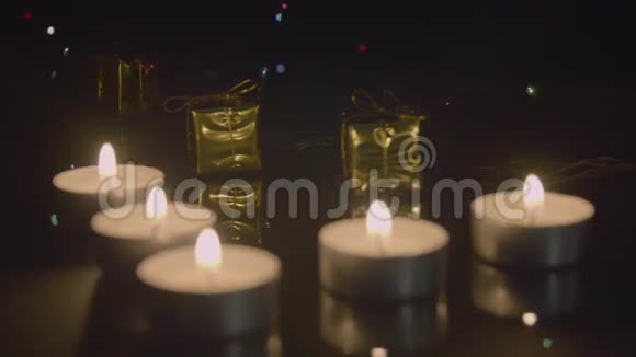 茶点蜡烛和黄金礼物作为圣诞装饰在闪烁的花环后面视频的预览图