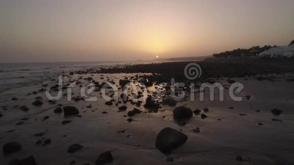 日落时海岸和海洋岩石的鸟瞰图视频的预览图