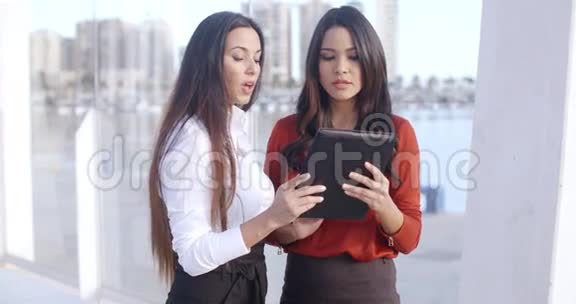两个女人在嘲笑平板电脑视频的预览图