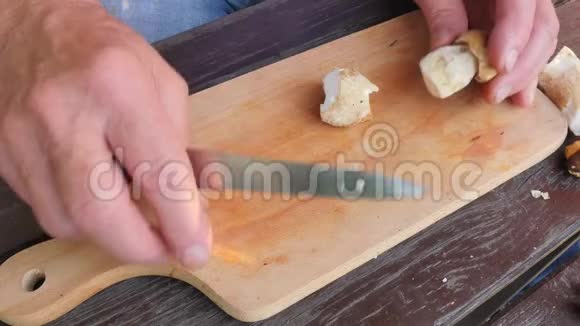 漂亮的野生蘑菇用刀切成木砧板上的小块手把牛肝菌切成薄片视频的预览图