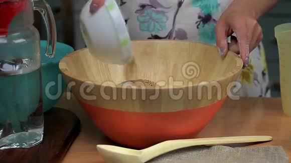 女人把亚麻籽和孜然倒在碗里视频的预览图