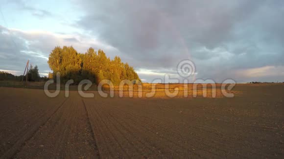 傍晚的彩虹覆盖着耕田和日落延时4K视频的预览图