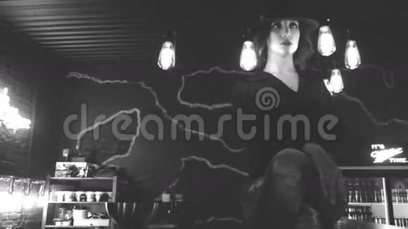 美丽的女孩坐在灯间的酒吧里视频的预览图