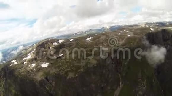 空中跳伞降落在被绿色和雪覆盖的山上极限运动视频的预览图