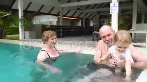 祖父母在游泳池里和孙女玩耍视频的预览图