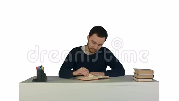 一个年轻人在白色笔记本上看书视频的预览图